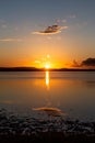 Perfectly symmetric clouds and and sun reflections on a lake at sunset