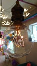 Perfectly transparent light bulb with heated electrical coil inside it