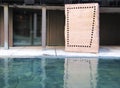 Perforated brown rectangular shaped stone reflecting in water