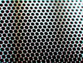 Perforated metal surface with chromatic aberration texture background