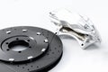 Performance braking system, new silver caliper and new perforated disk. Auto parts on white.