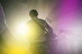 Performance of a rock band at a concert or party. Silhouettes of musicians, guitarist and drummer. People dance to the music, the Royalty Free Stock Photo