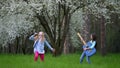 Performance two little girls fooling around outdoors in the spring. Play rock music in forest of antics and imitation pop musician