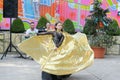 Performance of a young dancer. Little girl dance poses. Speech by a young girl in a black dress. Swinging a yellow fan