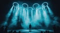 performer stands on stage under glowing hoops and dramatic lighting Royalty Free Stock Photo