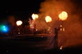 Performing fireshow at night surrounded by a crowd of people