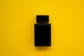 Perfume in beautiful black bottle on a yellow background, flat image