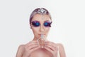 Perfume. Beautiful woman blue purple black artistic makeup with feathers eyelashes, natural lips and gray mettalic nails