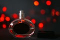 Perfume bottle on a black background with red lights