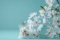 perfume bottle on flower with white blossoms and blue background