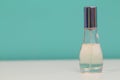 Perfume bottle with light blue cover isolated white and blue background Royalty Free Stock Photo