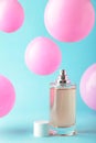 Perfume bottle with pink baloons on blue