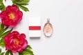 Perfume bottle and pink flowers peonies on light gray background top view Flat lay copy space. Perfumery, cosmetics, female Royalty Free Stock Photo