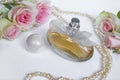 Perfume bottle with rose and pearls on a light background Royalty Free Stock Photo