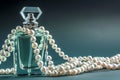 perfume bottle with string of pearls draped over it Royalty Free Stock Photo