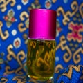 Perfume bottle with a yellow perfume color on a blue batik background Royalty Free Stock Photo