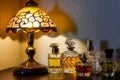 perfume bottles arranged by height next to a lit dressing table lamp Royalty Free Stock Photo