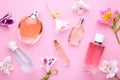 Perfume bottles with flowers on pink background Royalty Free Stock Photo