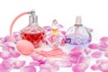 Perfume bottles with necklaces among flower petals on white background. Perfumery, cosmetics, fragrance collection Royalty Free Stock Photo