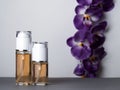 Perfume bottles and orchid gray background Royalty Free Stock Photo