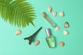 Perfume bottles, a statuette of the Eiffel Tower, fern leaf on blue pastel background. Summertime. Minimalism. Flat lay style.