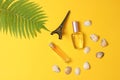 Perfume bottles, a statuette of the Eiffel Tower, fern leaf on a yellow pastel background. Summertime. Minimalism. Flat lay style.