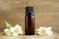 Spa perfume essential aroma oil glass bottle with flower blossoms on old wooden background