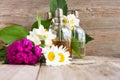 Spa perfume essential aroma oil glass bottles with flower blossoms on old wooden background Royalty Free Stock Photo