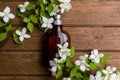 Perfume. Essential oil. Dark glass jar. Natural cosmetic. Natural perfume. Floral background. Bottle with fragrant water
