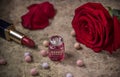 Perfume in a glass bottle, red rose flower and lipstick Royalty Free Stock Photo