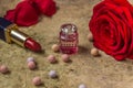 Perfume in a glass bottle, red rose flower and lipstick Royalty Free Stock Photo