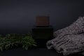 Perfume, Men`s perfume or lation After shave on a black next to a men`s sweater and Needles, Spruce. Luxury, Gift. Close-up Phot