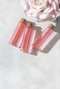 Perfumed Rose Water or essential oil in glass bottle and rose flower on a light background Royalty Free Stock Photo