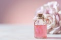 Perfumed Rose Water or essential oil in glass bottle and rose flower on a light background Royalty Free Stock Photo