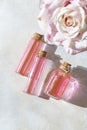 Perfumed Rose Water or essential oil in glass bottle and rose flower on a light background Royalty Free Stock Photo