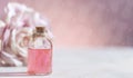 Perfumed Rose Water or essential oil in glass bottle and rose flower on a light background Royalty Free Stock Photo