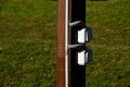 Pergola column made of wood prism. Two waterproof white switches or sockets are attached to it. The cable supplies electricity in