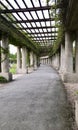 A pergola in Wroclaw, people are resting while walking along a corridor made of columns