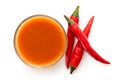 Peri peri chilli sauce in a glass bowl next to three red chillies isolated on white from above Royalty Free Stock Photo