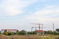 Peri urban scenery of the suburb of Belgrade, with cranes on a construction site in the middle of fields