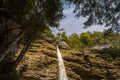 Pericnik waterfall with water falling down a mountain, seen from below, with a blue sky in summer.