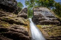 Pericnik waterfall with water falling down a mountain, seen from below, with a blue sky in summer.