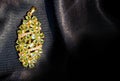 Peridot and Diamond Jewel or gems pendant on black shiny polyester fabric background. Collection of natural gemstones accessories