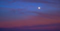 Perigee Moon Supermoon surrounded by purple clouds at sunset with a dark blue sky