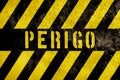 Perigo in Portuguese language, danger warning sign text with yellow and dark stripes painted over concrete wall facade texture Royalty Free Stock Photo
