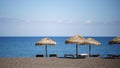 Perissa beach covered with black sand view with sunbeds and umbrellas on Santorini, Greece Royalty Free Stock Photo