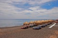 Perissa beach at Santorini, Greece with sunbathing hut & sundeck for visitors to enjoy the summer sun & relax rest sleep read