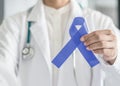 Periwinkle blue ribbon awareness with color bow on medical doctor`s hand for stomach and small intestine cancer, esophageal cancer Royalty Free Stock Photo
