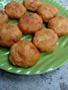 Perkedel kentang or fried potato dumplings are placed on a green plate.