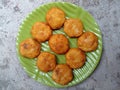 Perkedel kentang or fried potato dumplings are placed on a green plate.